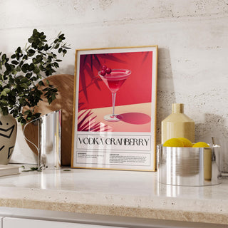 Home Bar Print of a pink vodka cranberry cocktail with red and cream colours leaning on a kitchen counter near lemons