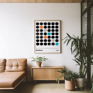 Graphic Prints wall art of coloured dots grid in bauhaus style above wooden sideboard with potted plant