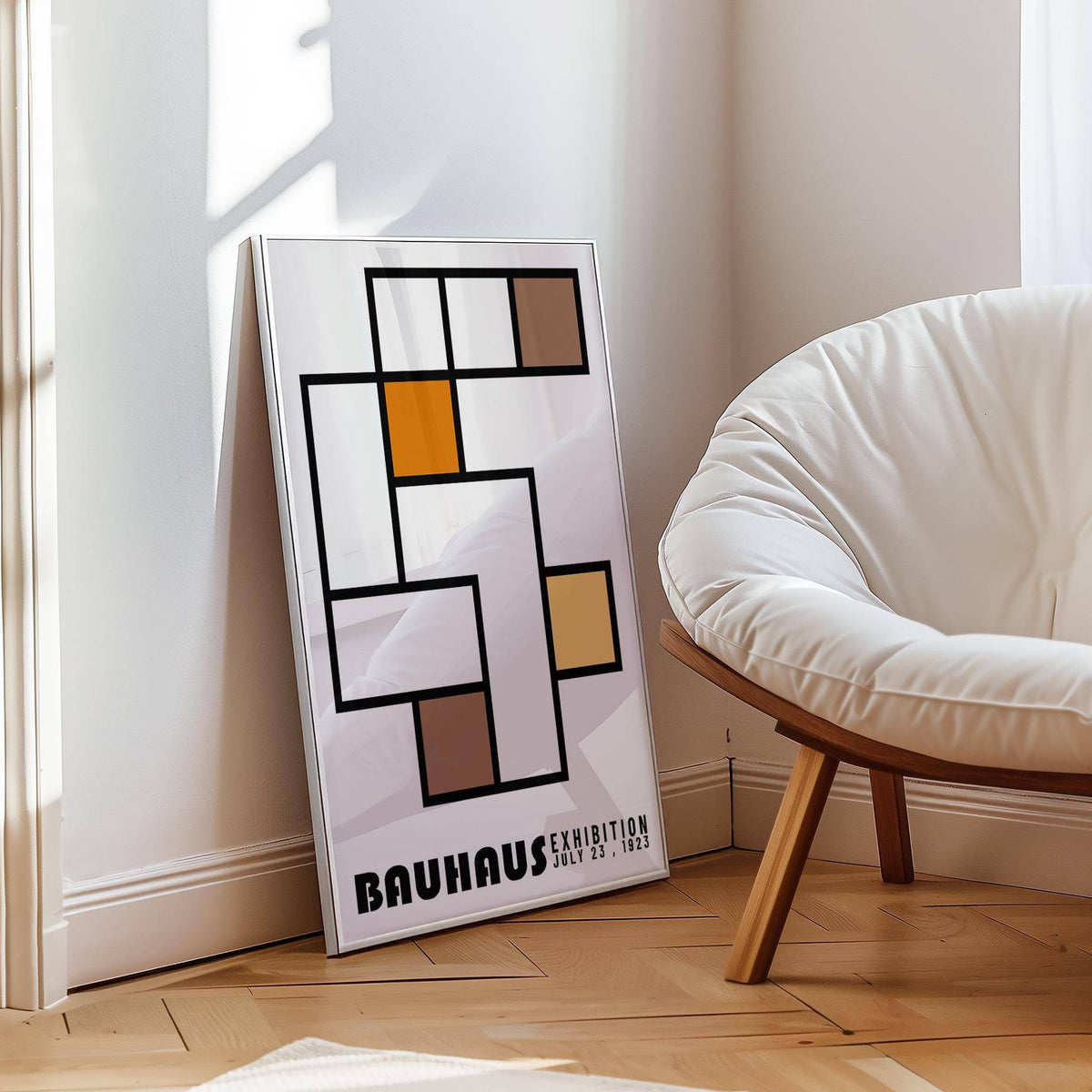 Print leaning on a wooden floor showing Geometric Abstract Art with brown and orange blocks next to a white cushioned chair
