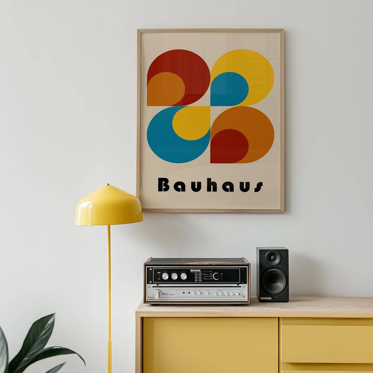 Geometric prints framed print with red yellow and blue abstract shapes above a yellow sideboard and lamp