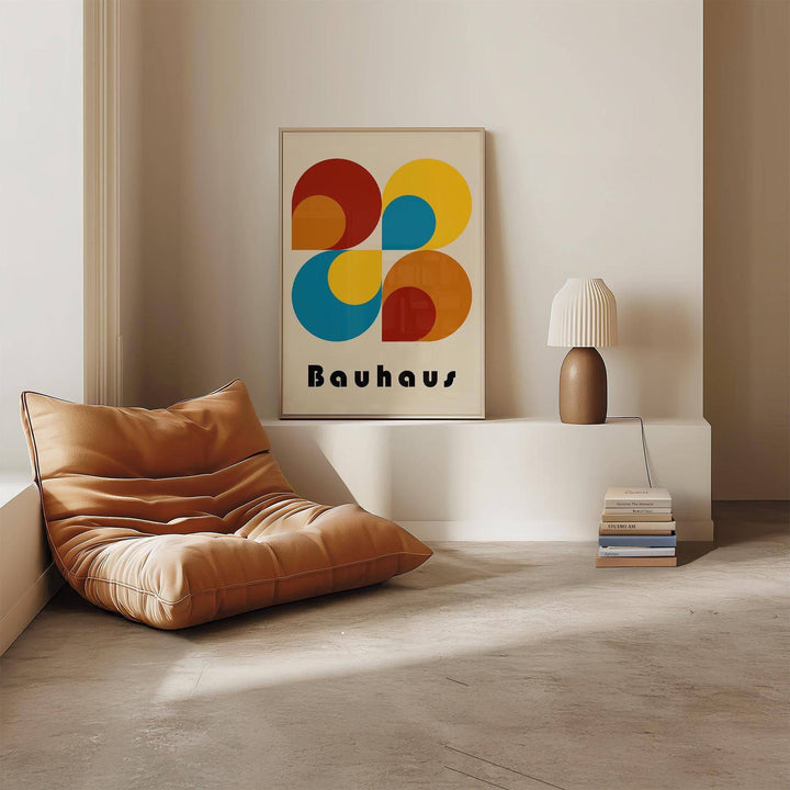 Print leaning with geometric prints and abstract shapes in blue yellow and red near a brown chair in a minimalist room