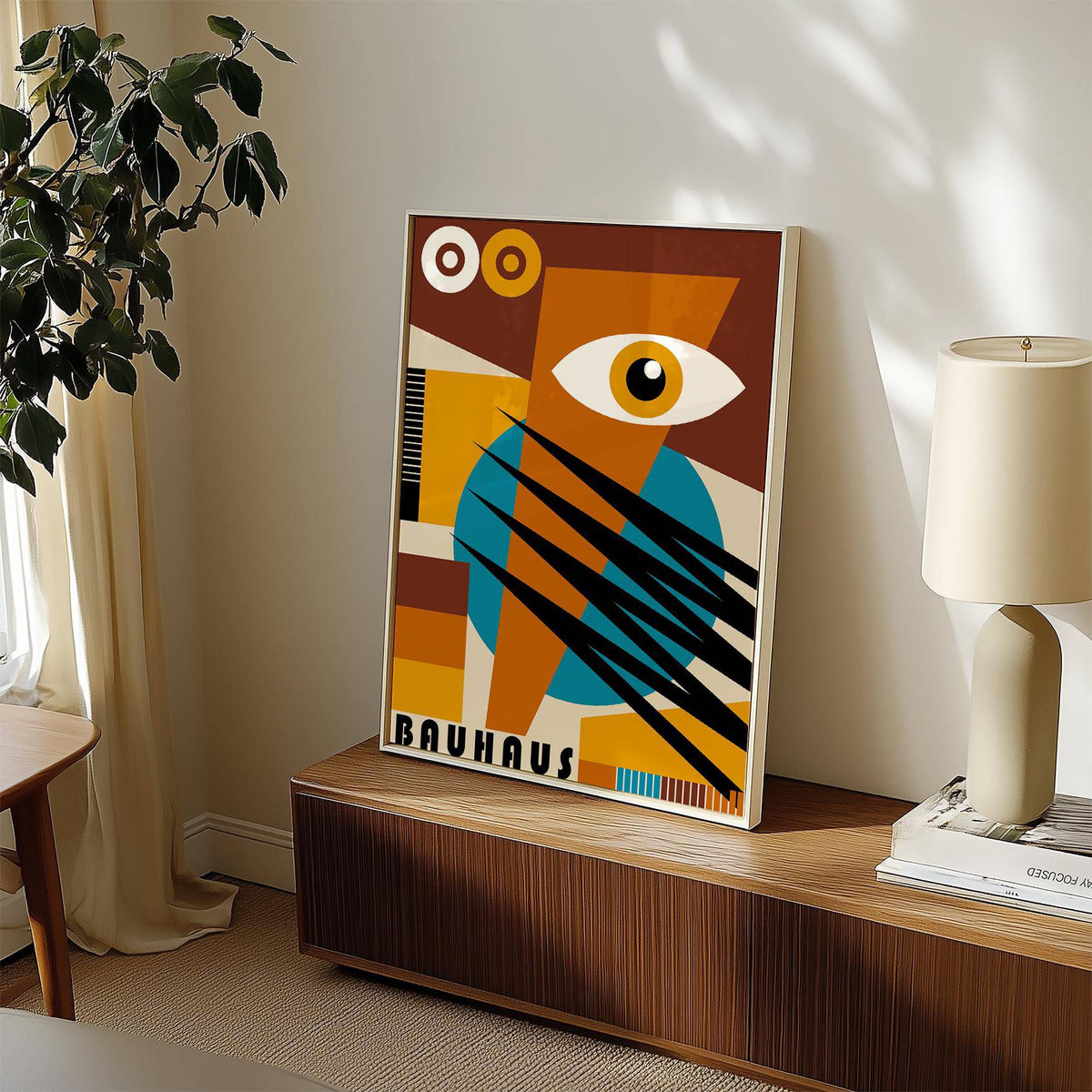 Geometric Poster print leaning on a wooden sideboard next to a lamp and plant in soft natural light