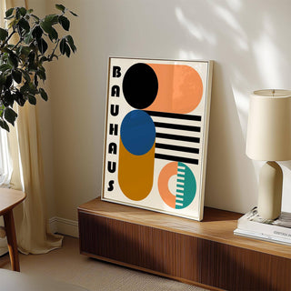 Print leaning on a shelf with bauhaus geometric shapes in black blue and ochre near a lamp