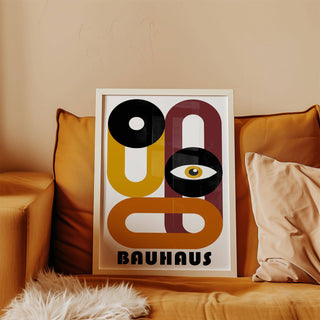 Framed abstract eye shape in Bauhaus style with ochre and black on sofa with cushions