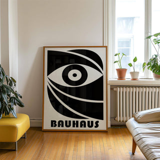 Black Eye Poster leaning on floor with abstract eye in black and white and a green plant beside it