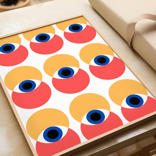 Framed Wall Art Eye print with abstract red and yellow eyes pattern on a table