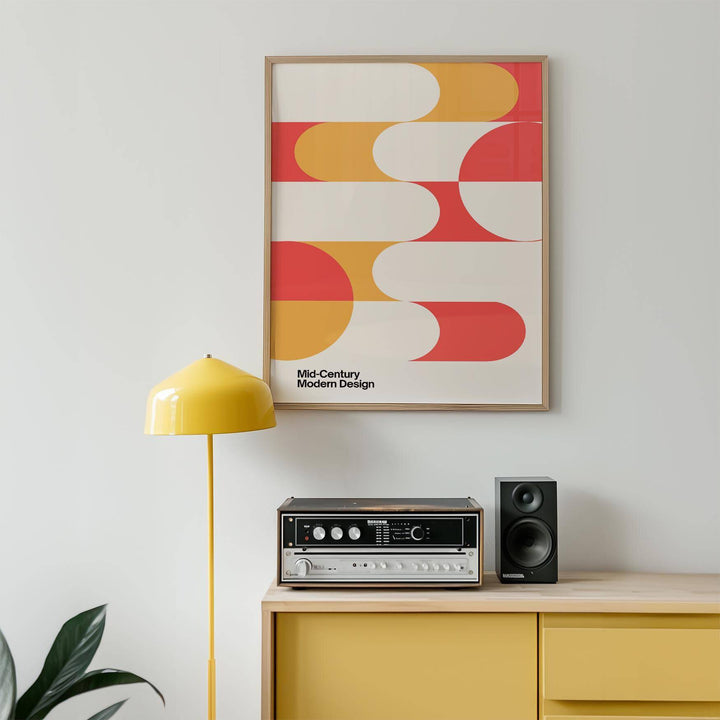 Framed Mid Century Art print with coral and yellow geometric shapes above a yellow sideboard and vintage sound system