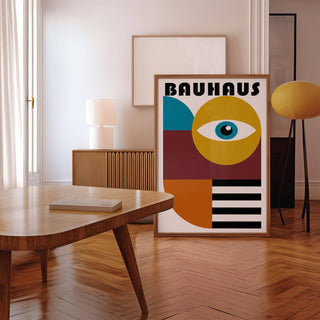 Retro wall art with a stylized eye and abstract shapes leaning on the floor by a yellow lamp