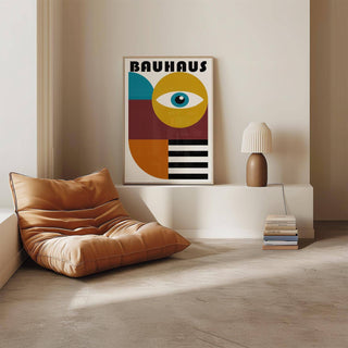 Retro wall art leaning on a white shelf by a stack of books and a lamp in a beige room