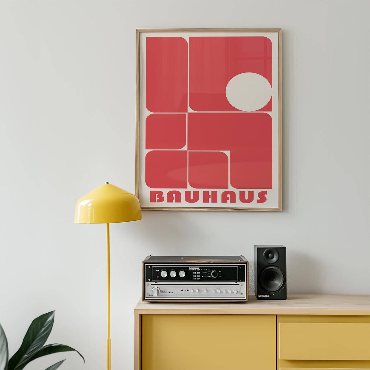 Red wall art decor with rounded rectangles and a white circle above a yellow lamp and vintage stereo in a room