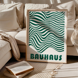 Green and White Wall Art leaning on a beige sofa with cushions and books on a rug