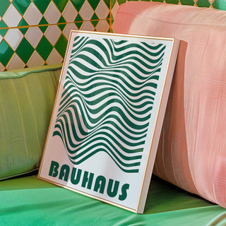 Framed close-up of green and white wavy stripes with Bauhaus text leaning on cushions