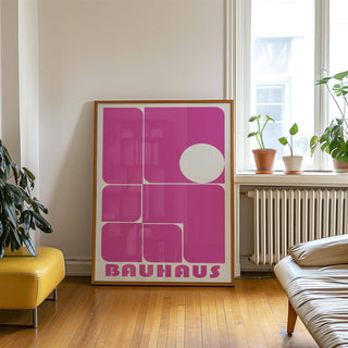 Wall Art Pink leaning print with pink and white geometric shapes beside a yellow ottoman