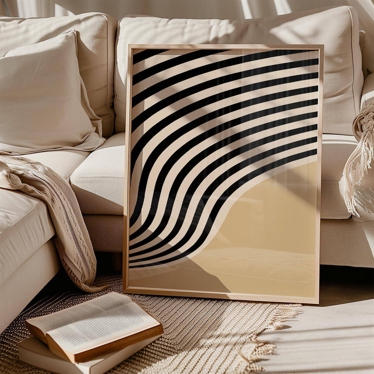Print leaning on a beige sofa with beige abstract art featuring curved black and beige stripes