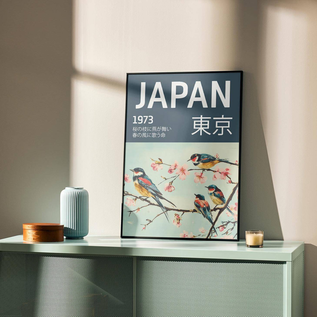 Japanese Bird Wall Art leaning on a green sideboard with blue vase and wooden box in soft natural light