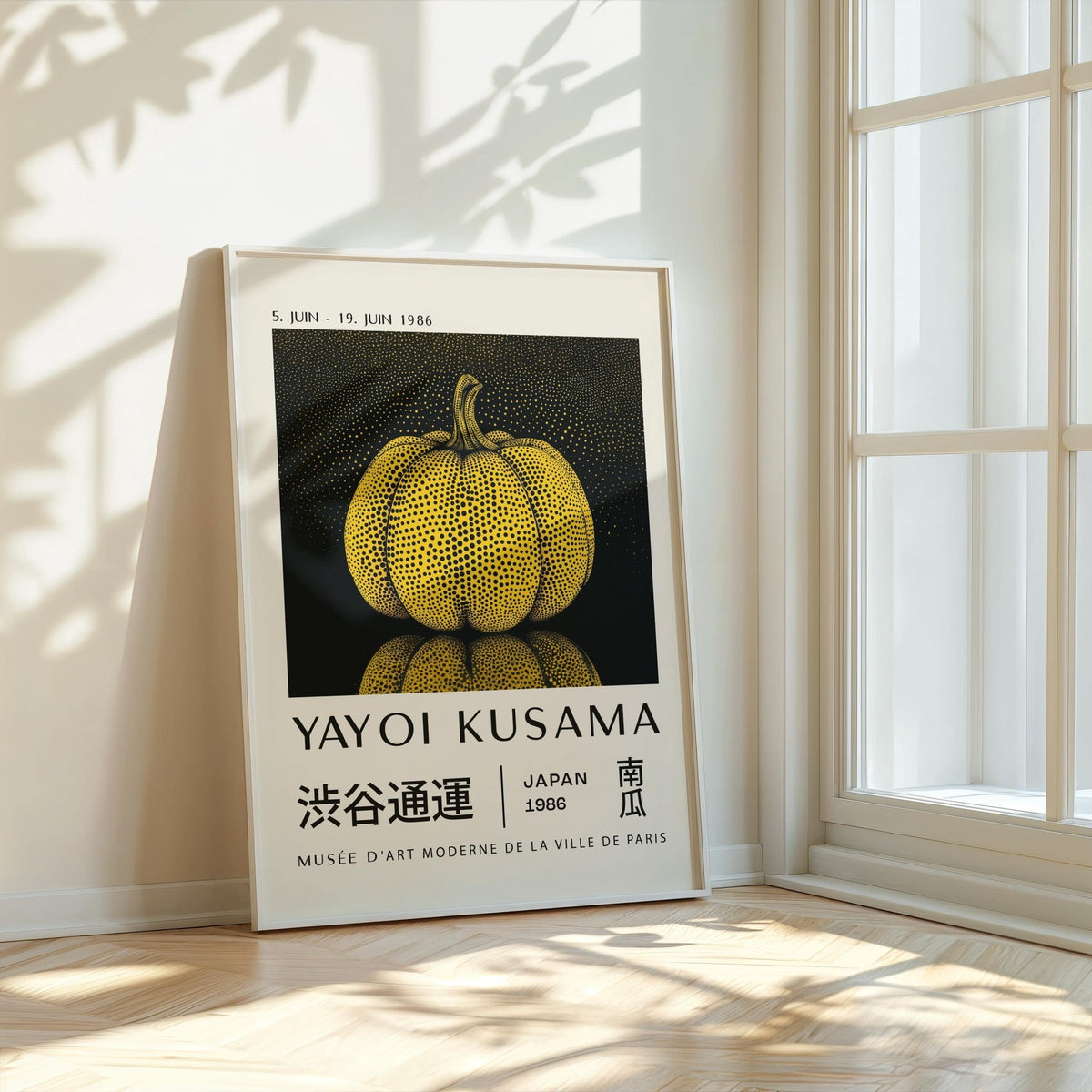 Print leaning on a floor beside a window featuring a yellow polka dot pumpkin illustration with black background