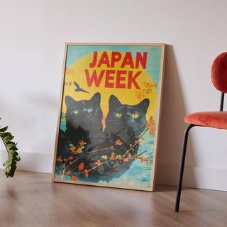 Retro wall prints leaning with black cats and bright yellow sun near a plant and red chair