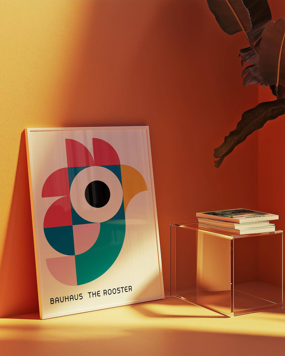Print leaning on a floor with geometric rooster art in blue pink yellow near a stack of books on a glass side table