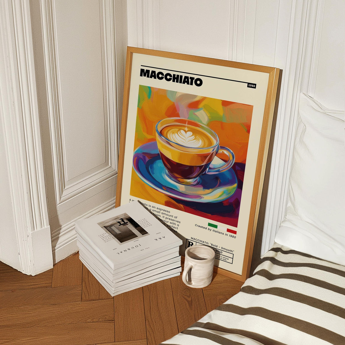 Print leaning on floor of coffee poster with colourful macchiato cup next to books and mug