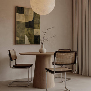 Wabi Sabi Green wall art with abstract olive shapes in muted greens above a wooden dining table and cane chairs