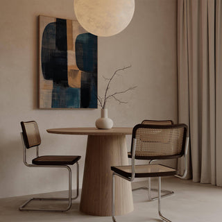 Wabi Sabi Painting with abstract shapes in blue and brown hung above a wooden dining table with chairs