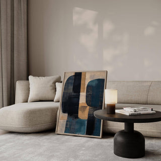 Print leaning on a sofa in a living room with abstract shapes in blue and tan tones