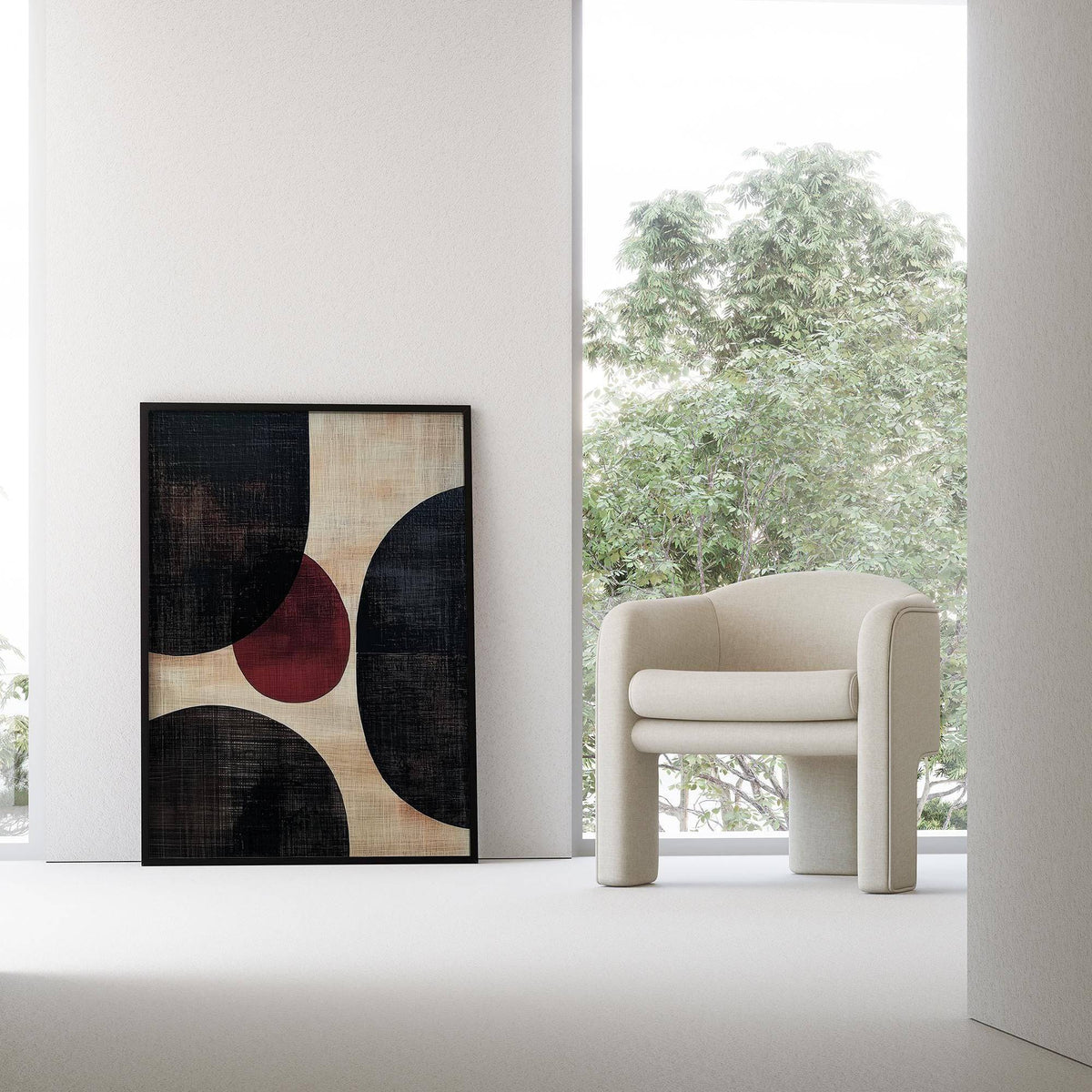 Wall Art Abstract leaning on a wall with rounded shapes in black and burgundy beside a cream armchair