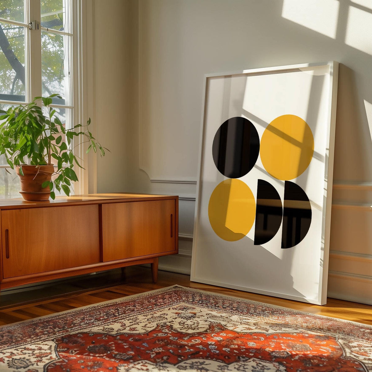 Print leaning on the floor of geometric posters with black and yellow shapes near a wooden sideboard and plant