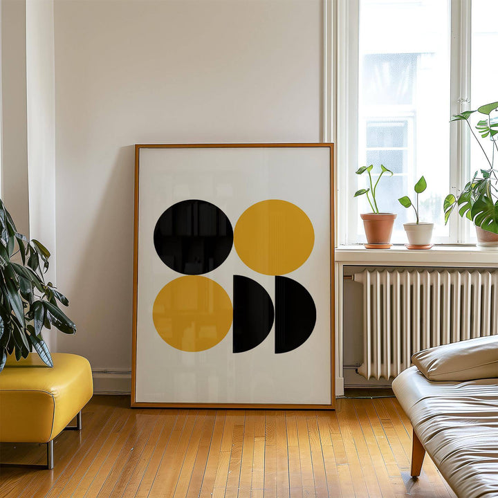 Geometric posters print leaning on floor by a window with potted plants and wooden flooring