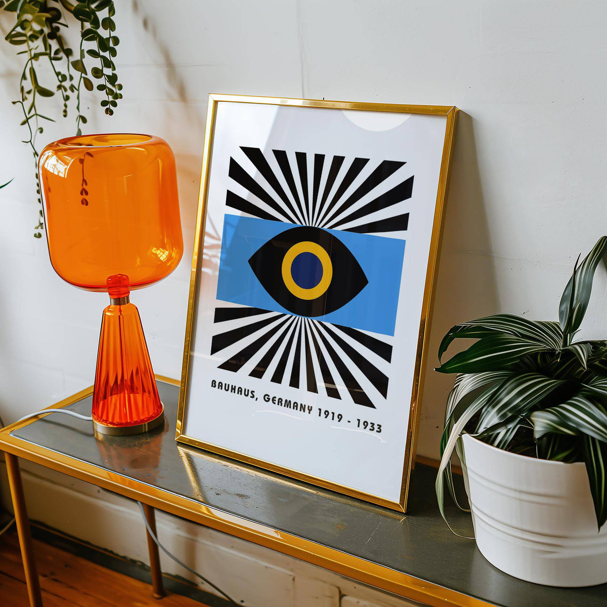 Framed Modern Art Geometric print with abstract eye and blue, black and yellow colours leaning on a table with an orange lamp
