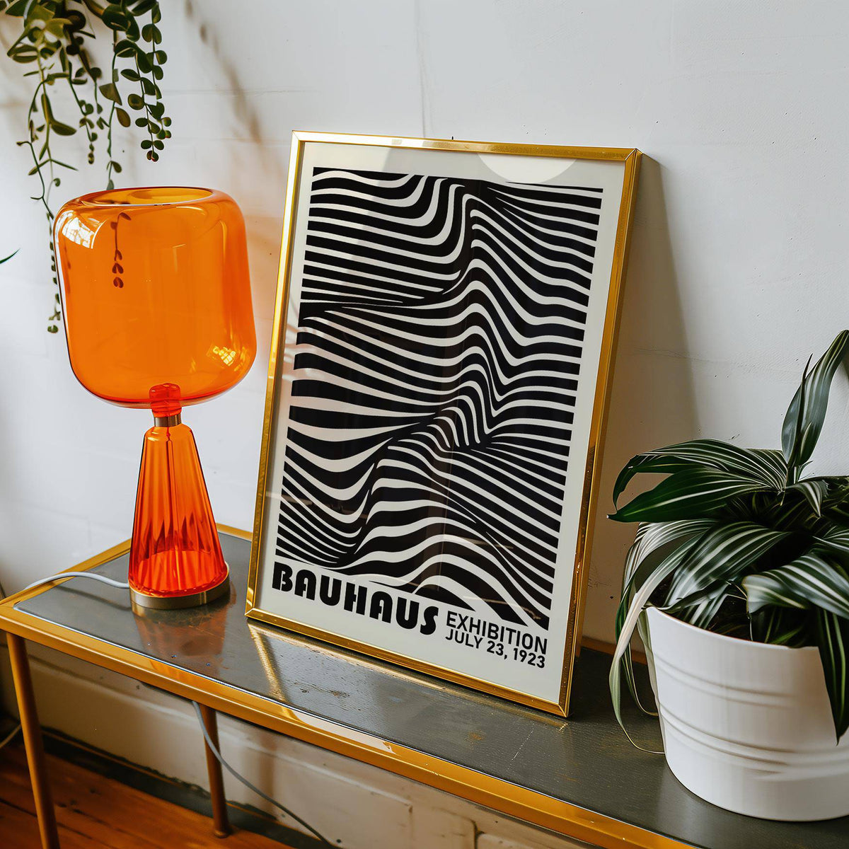 Framed Black Minimalist Wall Art with black and white optical illusion leaning on a metallic table with an orange lamp