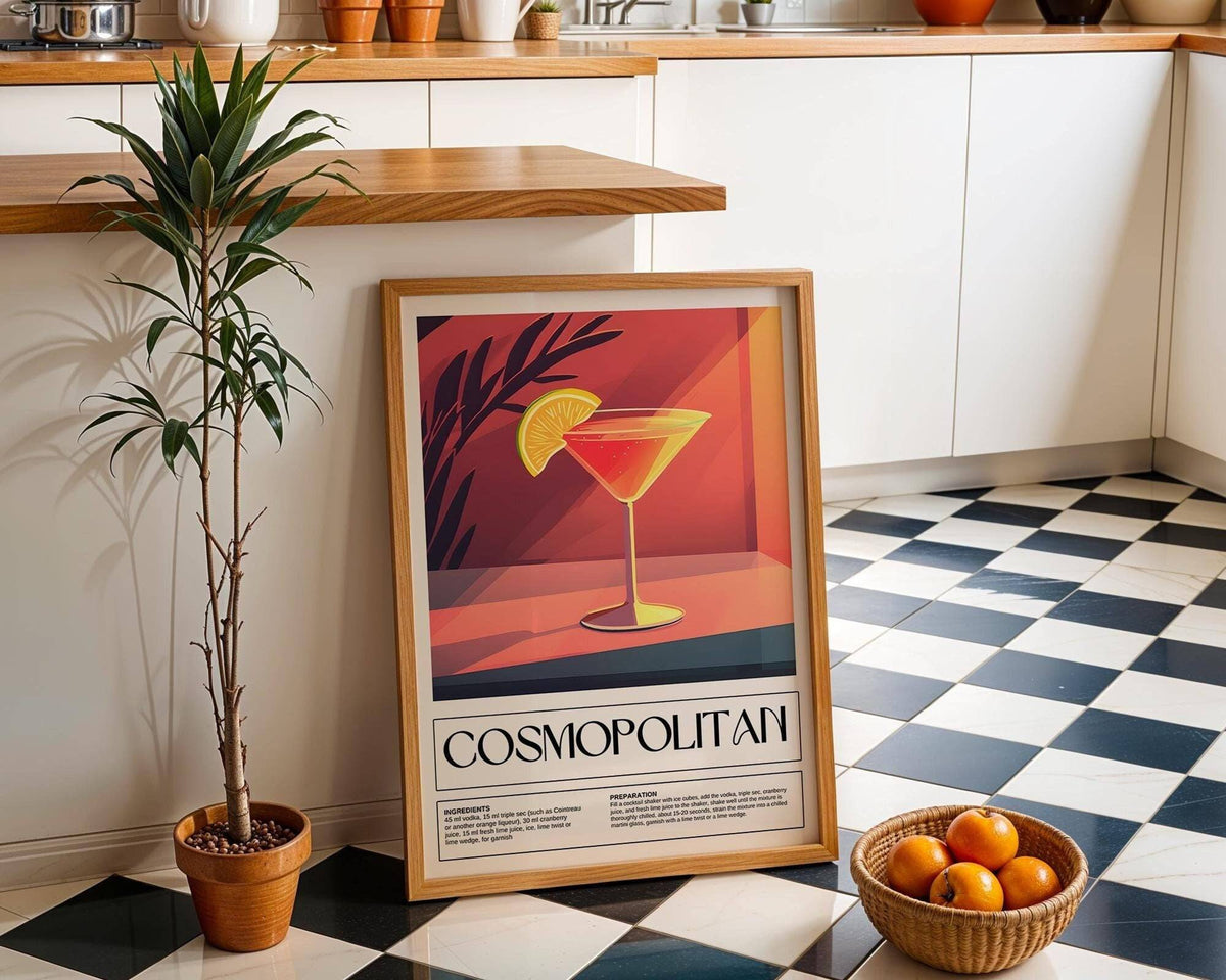 Drink Poster Art print leaning on a black and white tiled floor beside a potted plant and basket of oranges in a kitchen