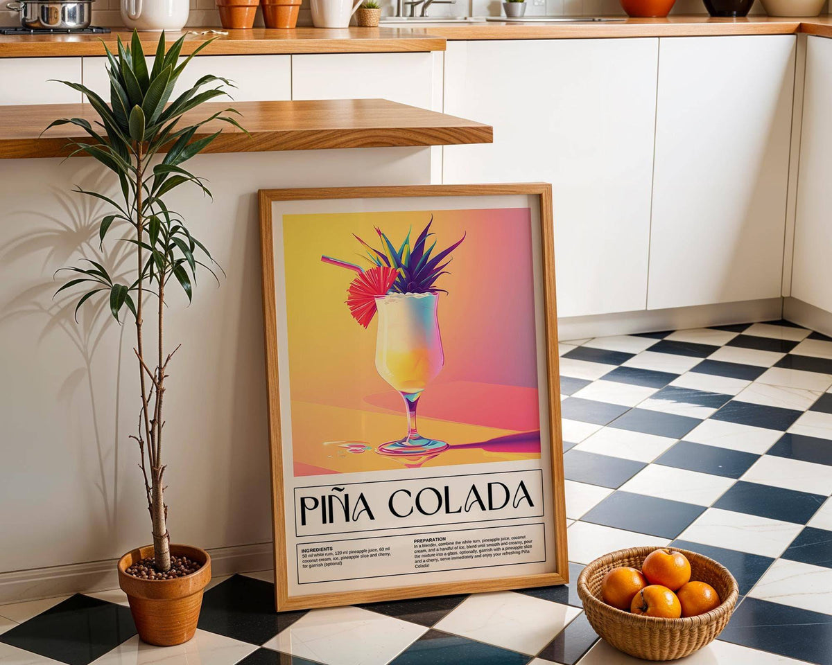 Drink wall art of piña colada cocktail illustration leaning on a kitchen floor beside a plant and basket of oranges