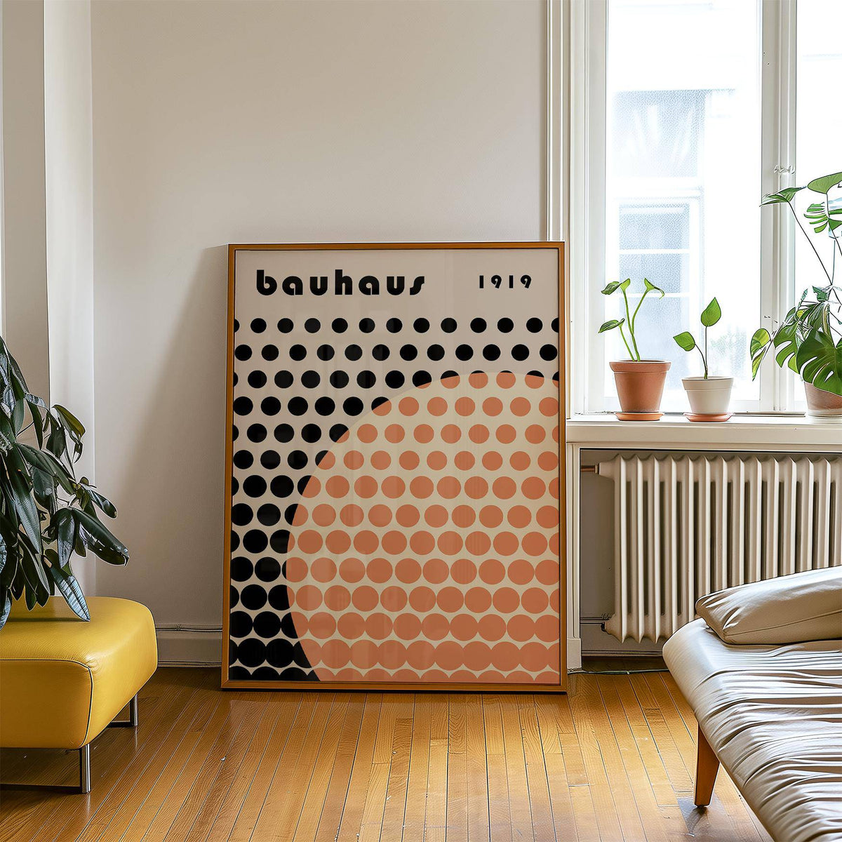 Cool Art Poster leaning on floor with peach and black geometric shapes near green plants and yellow bench