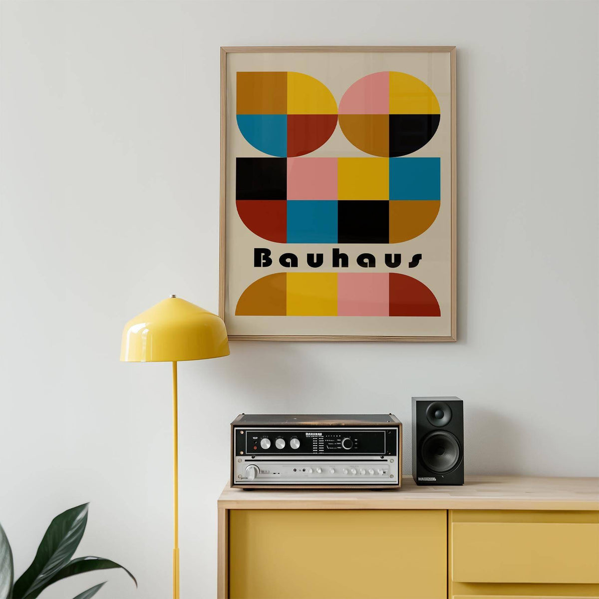 Framed Colorful Geometric Wall Art with bold shapes in yellow pink and black above a yellow sideboard and stereo