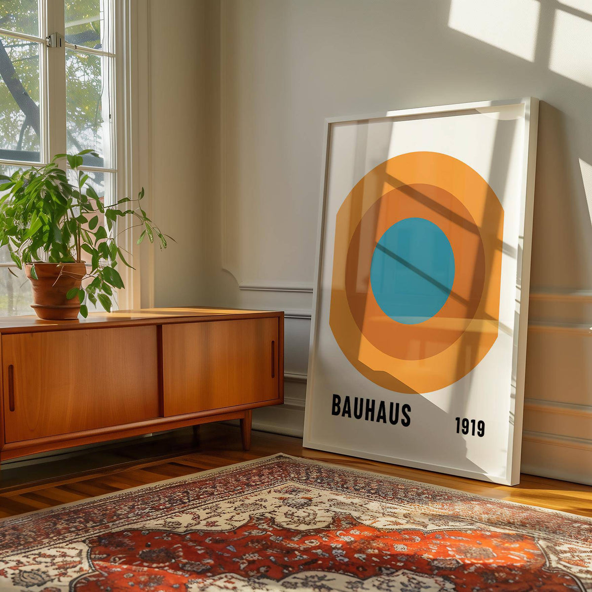 Bauhaus Circle Poster leaning on a wooden floor with sunlight and a plant on a sideboard