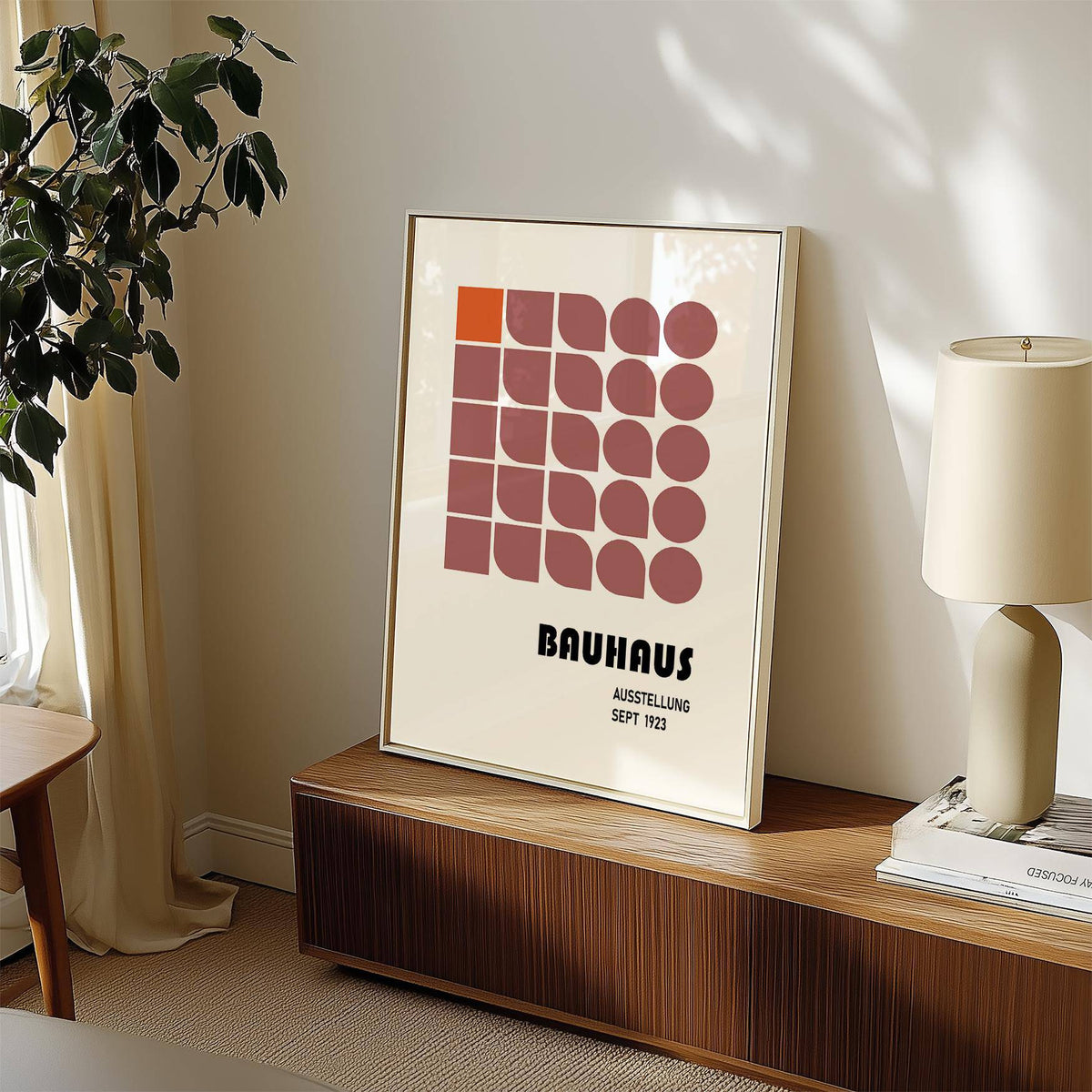 Wall Hanging Geometric print with minimalist shapes and muted colours leaning on a sideboard with a lamp