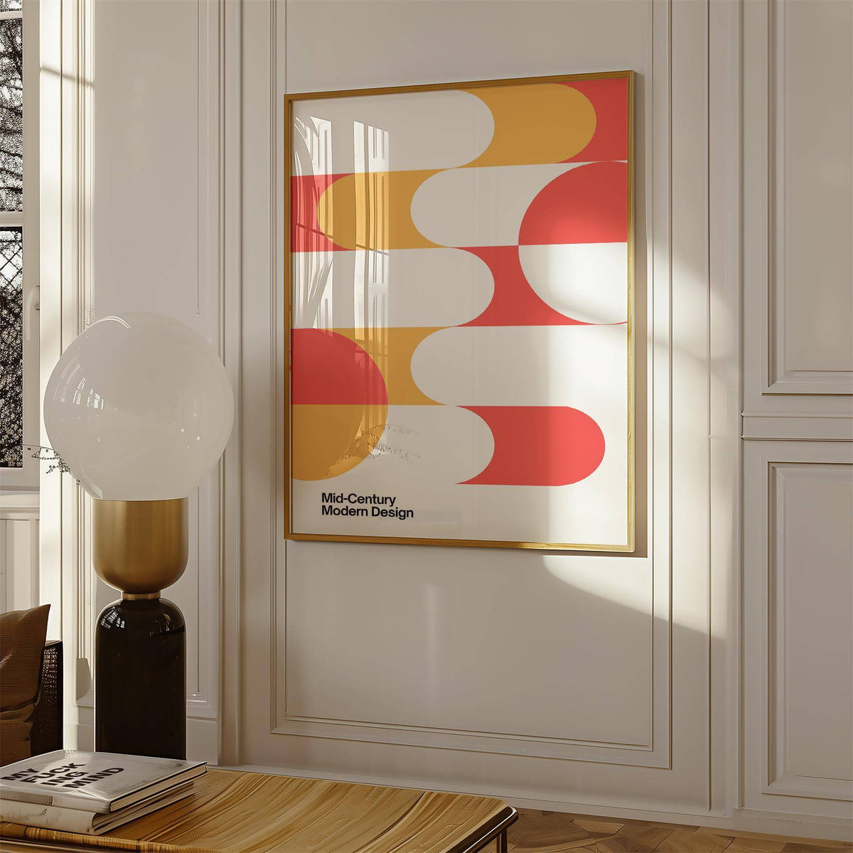 Mid Century Art print with rounded coral and ochre shapes in a sunlit room with a white lamp on a wooden table