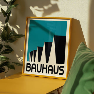Framed Bauhaus Poster Blue with abstract rooftops in black and blue leaning on a yellow shelf near a plant