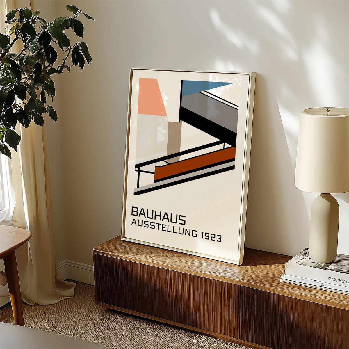 Print leaning on a wooden surface of Bauhaus Exhibition Poster 1923 with minimalist geometric shapes and muted colours in natural light