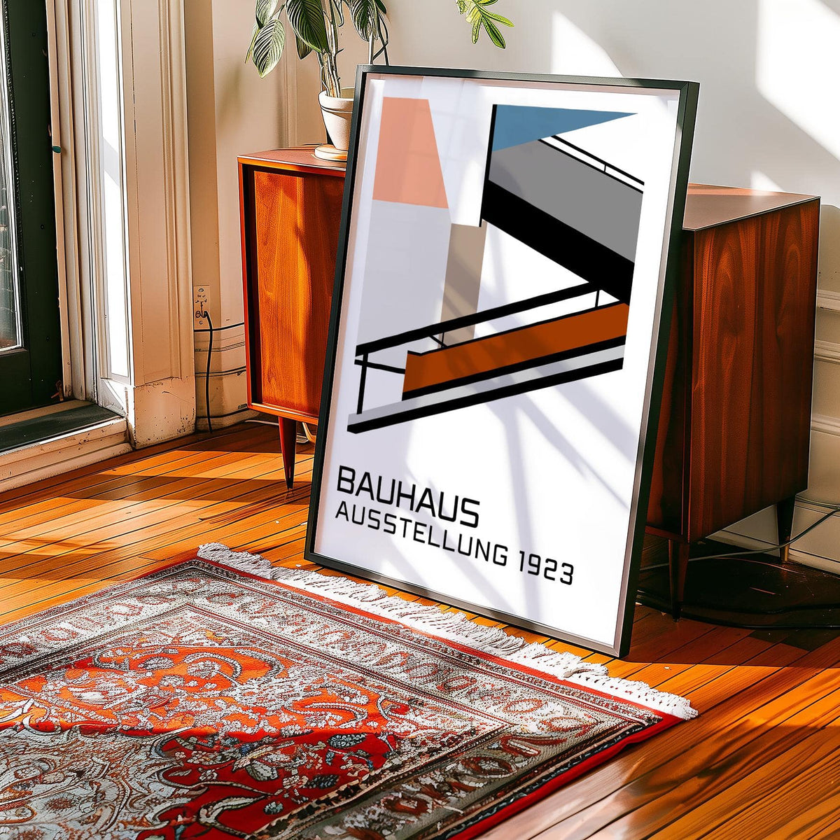 Print leaning on a wooden floor with a patterned red rug and wooden cabinet nearby