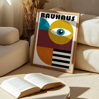 Retro wall art framed print leaning on a carpet with beige cushions and a dried flower arrangement
