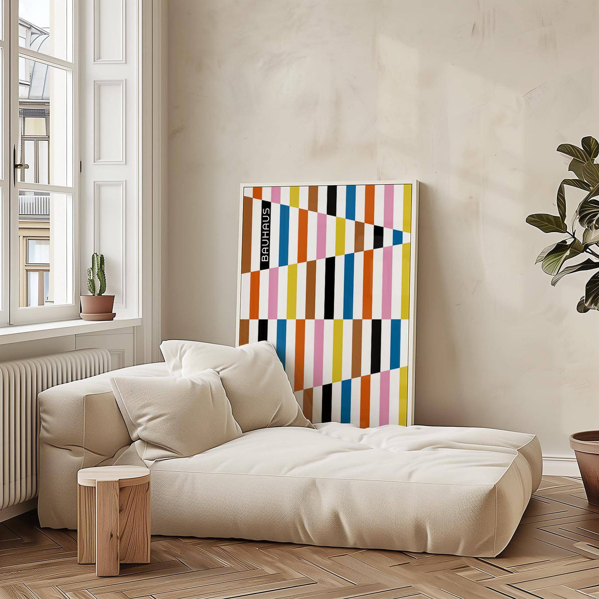 Colorful Block Print leaning on wall with geometric blocks in muted tones beside a cream sofa and plant