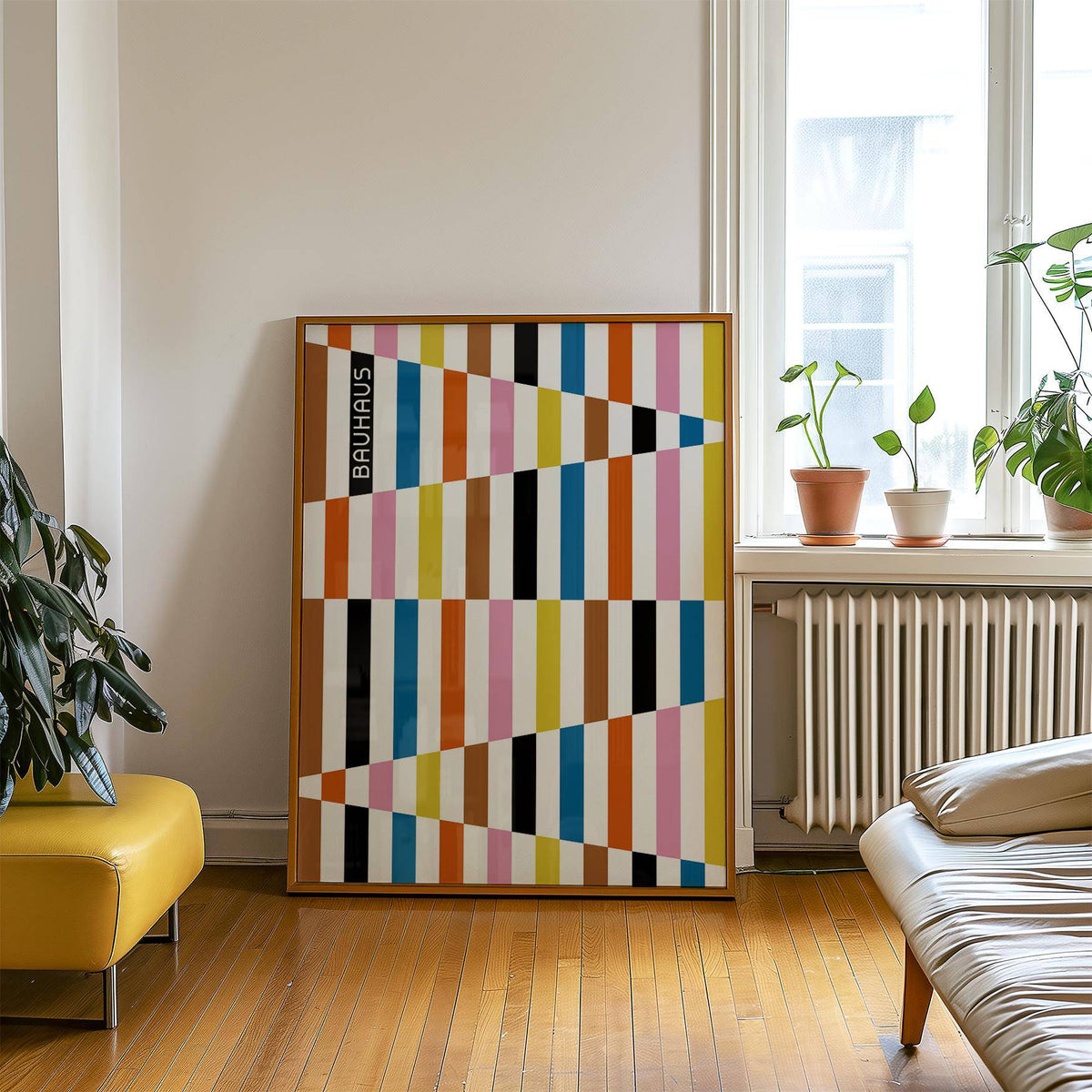 Colorful Block Print leaning on a wooden floor with plants and sofa nearby in a living room