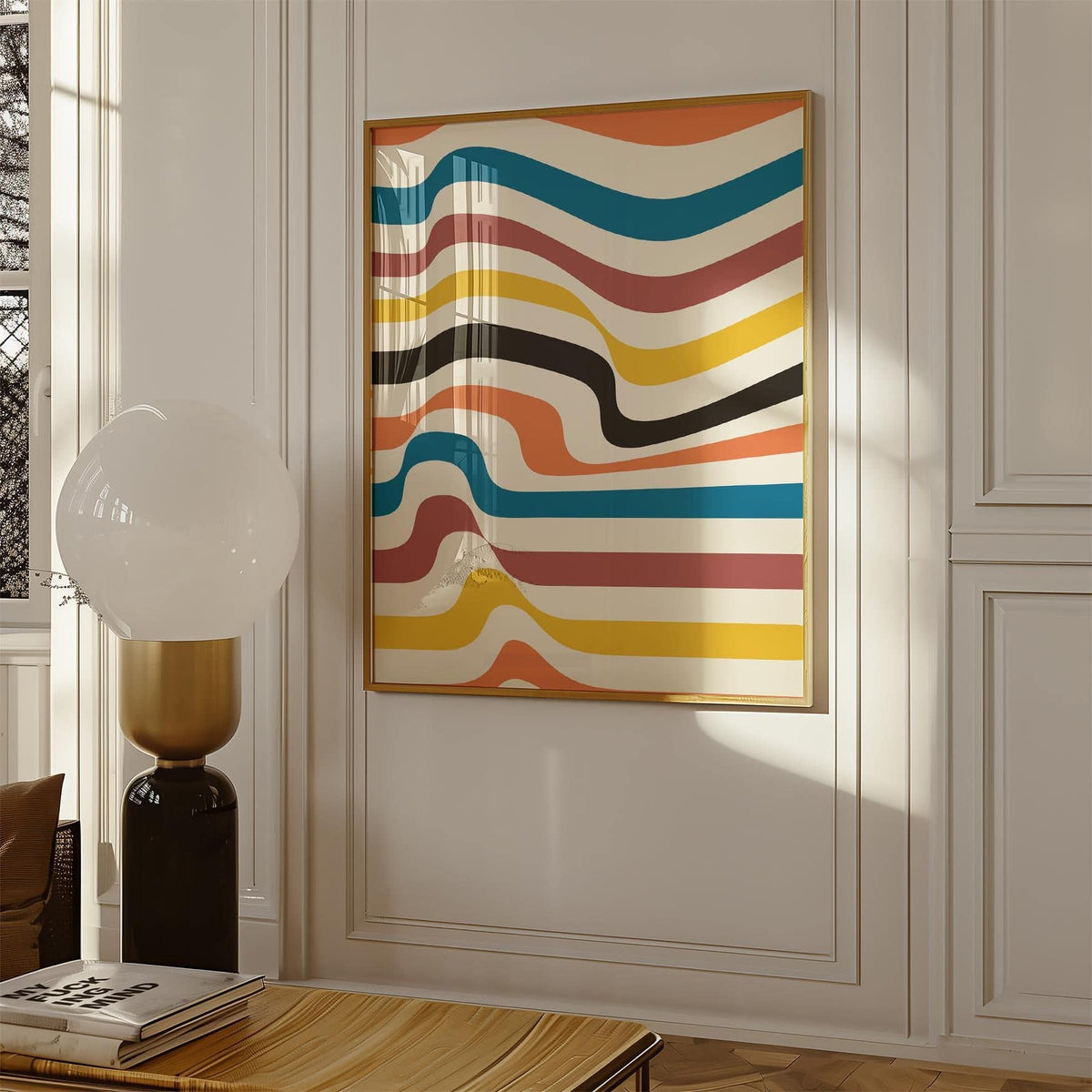 Framed art work for wall with wavy colourful stripes in warm tones and teal above a wooden table with books