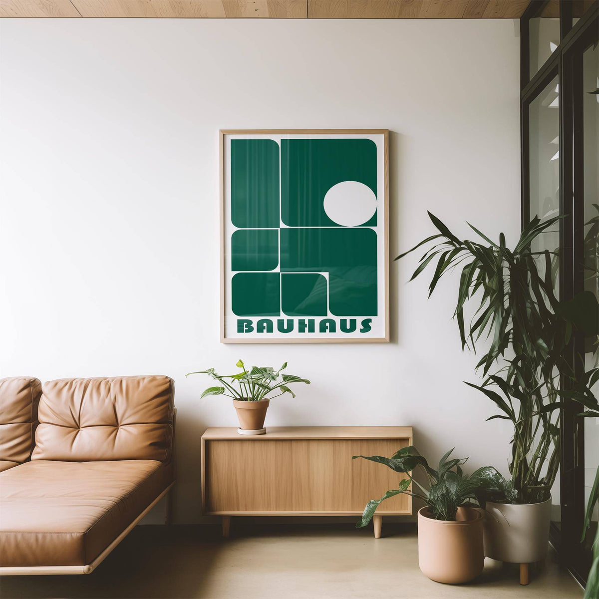 Art for Office framed print with green geometric shapes and Bauhaus text above a wooden sideboard with a plant