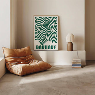 Green and white wall art leaning on a white shelf with a brown lamp and brown leather cushion beside it