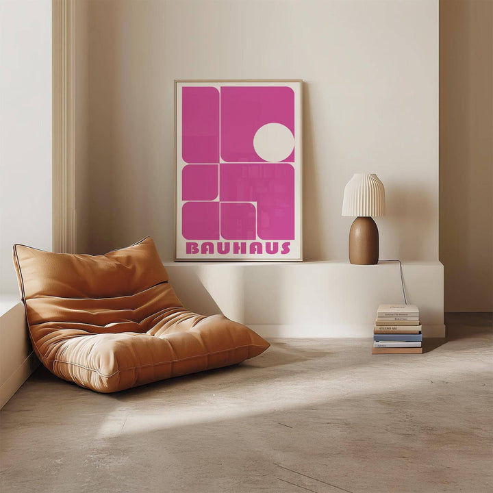 Wall Art Pink framed print with abstract geometric shapes in pink and white beside a lamp on a white ledge
