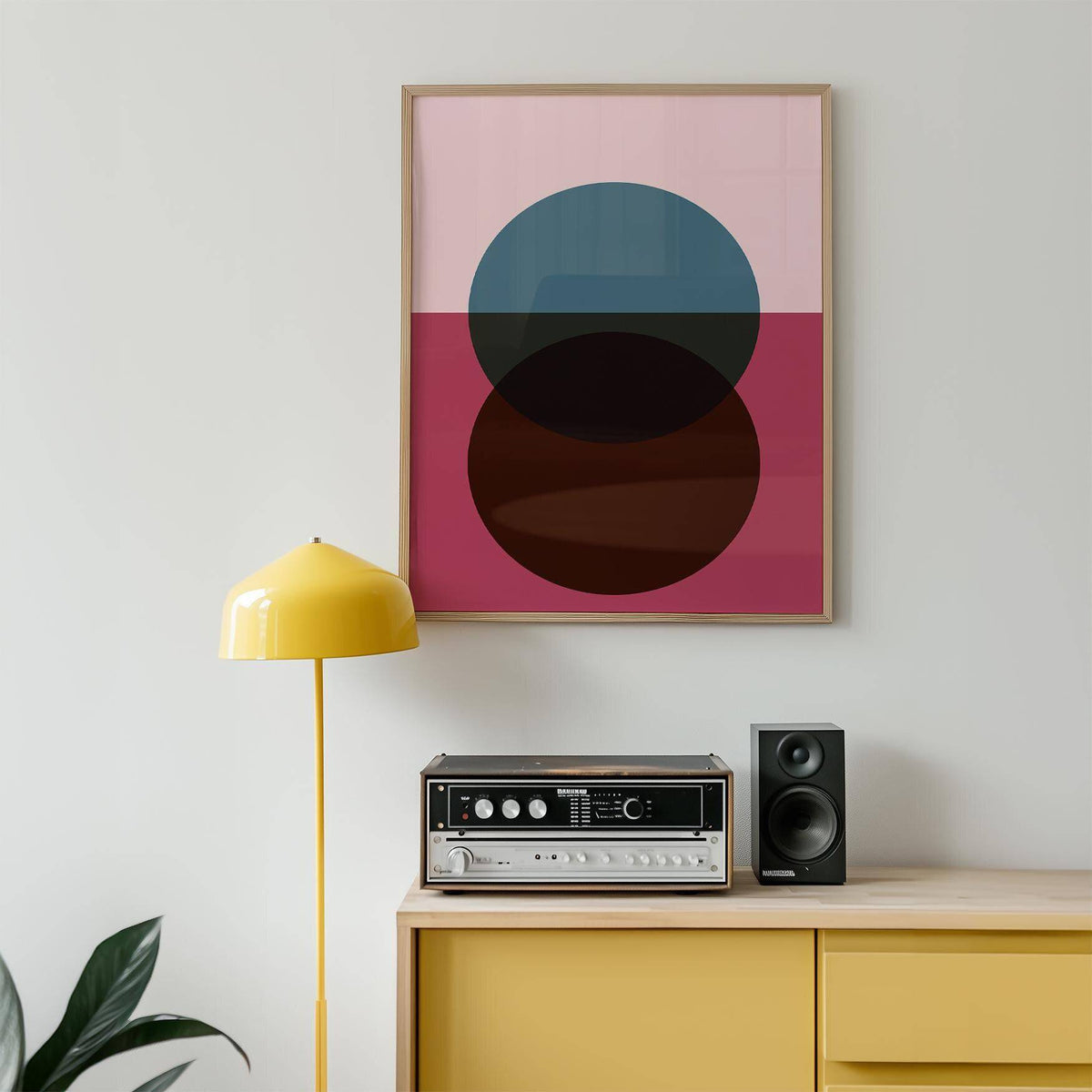 Purple wall art with overlapping circles in blue and brown above a yellow sideboard with record player and speaker