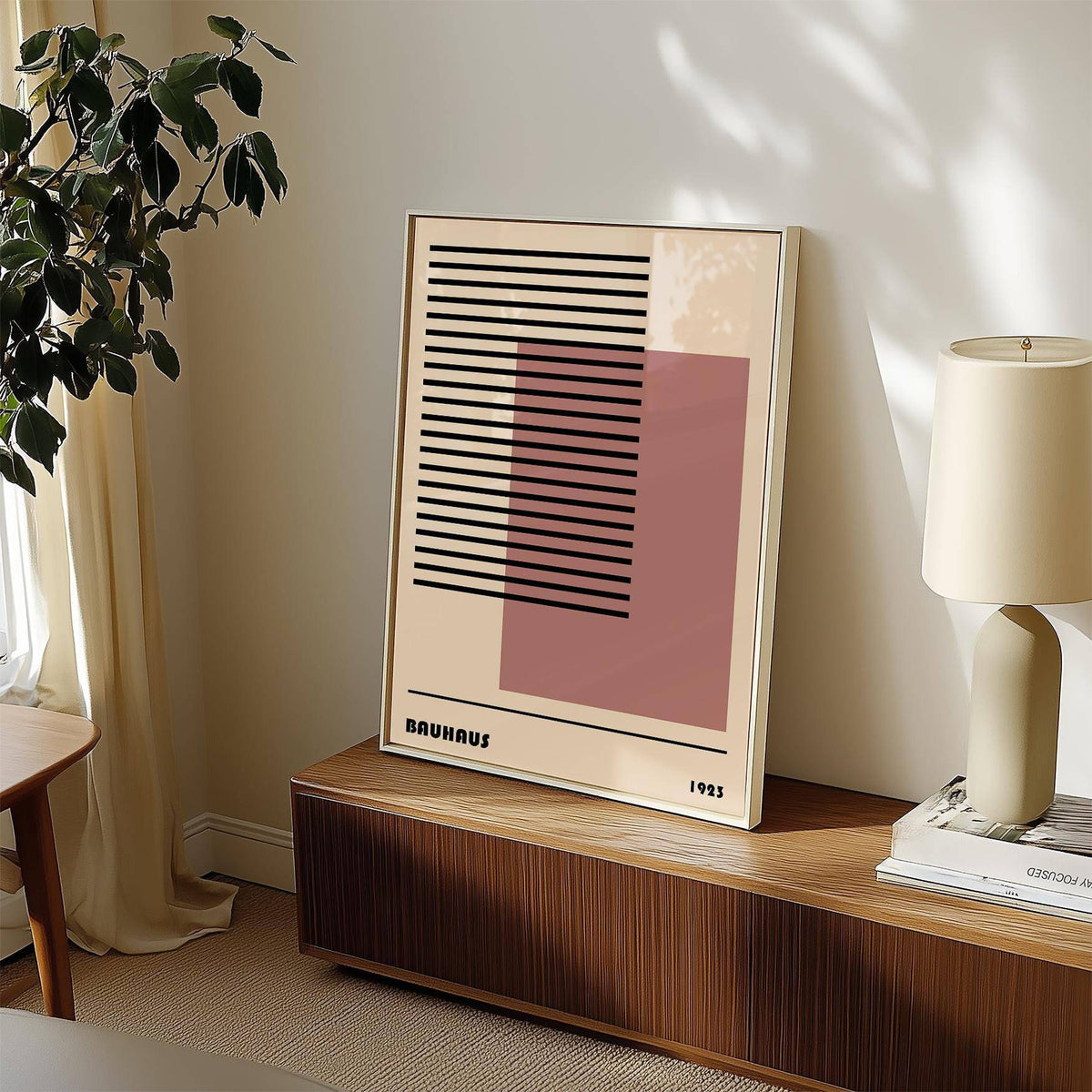 Bauhaus 1923 Art print leaning on a wooden sideboard with a beige lamp and green plant nearby